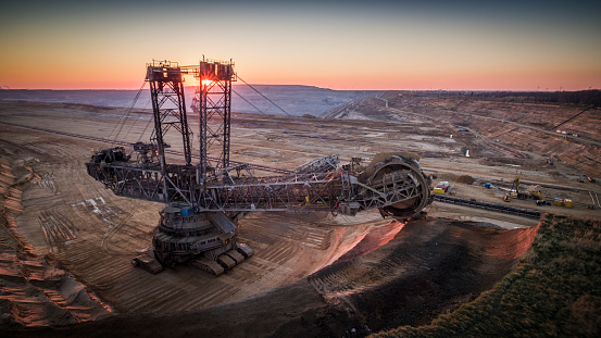 Aerial shot of a giant open pit lignite mine Hambach in Germany. Large bucket excavator mining machinery. Moody light at sunset.